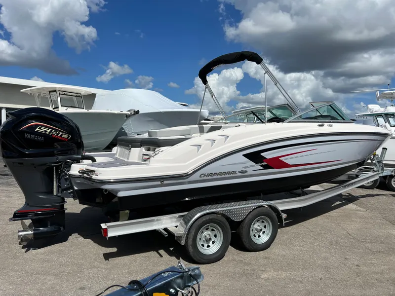 Slide: The Image of 2023 Chaparral 23 SSi OB boat on a trailer under a cloudy sky. - 2