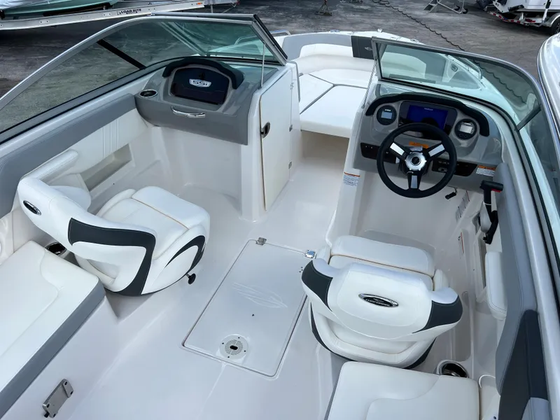Slide: The Image of 2023 Chaparral 23 SSi OB boat interior with white seating and modern dashboard. - 6