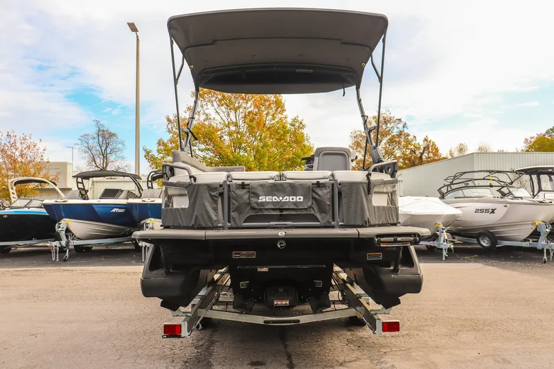 Slide: The Image of 2024 Sea-Doo Switch Sport 21 pontoon boat, rear view, parked in a dealership lot. - 3