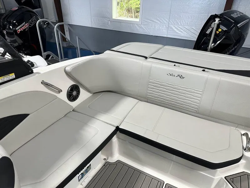 Slide: The Image of 2024 Sea Ray 210 SPX OB boat interior with white cushioned seating. - 10