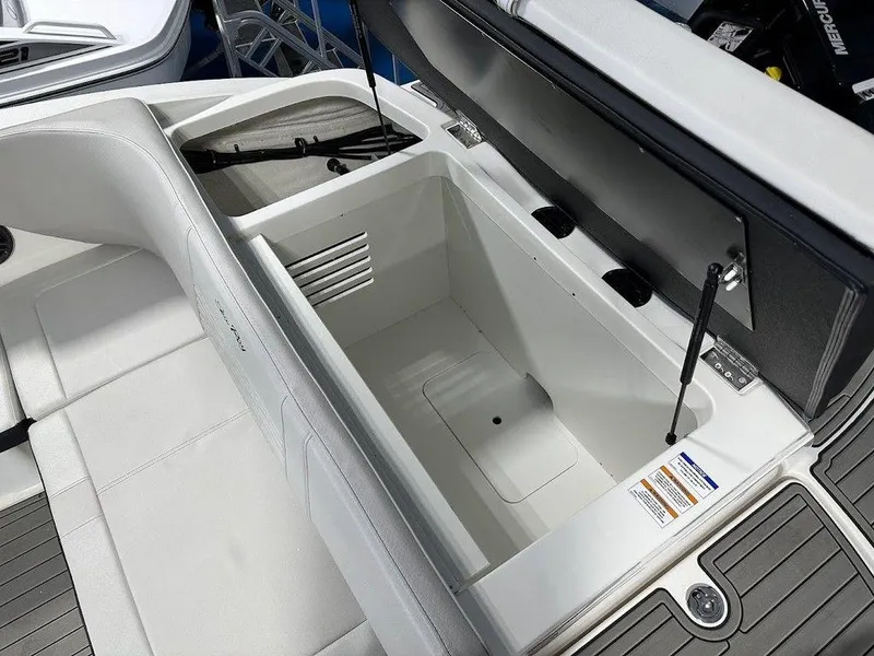 Slide: The Image of 2024 Sea Ray 210 SPX OB boat storage compartment with open lid. - 3