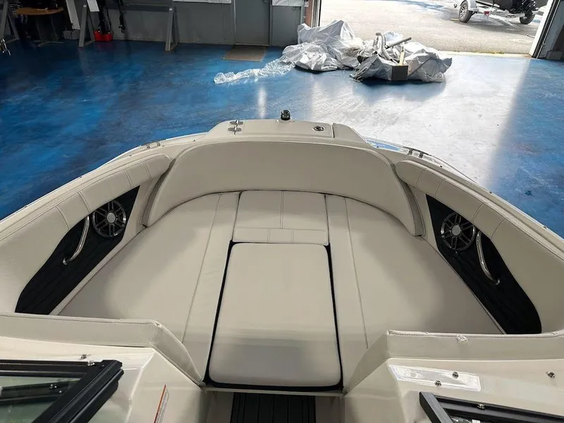 Slide: The Image of 2024 Sea Ray 210 SPX OB boat interior, spacious bow seating area in a showroom. - 9