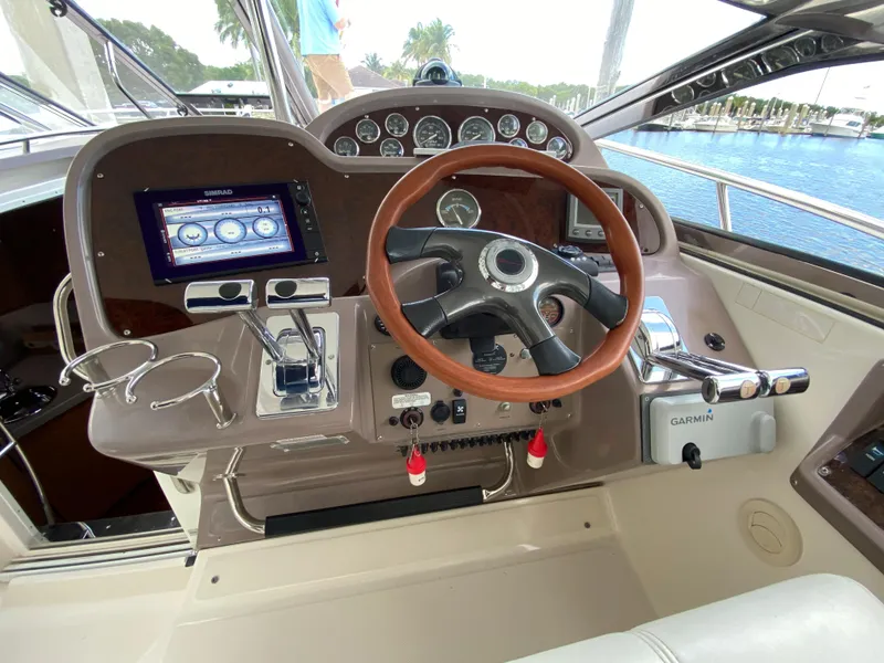 Slide: The Image of 2004 Regal 3860 Commodore boat helm with wooden steering wheel and modern navigation equipment. - 10