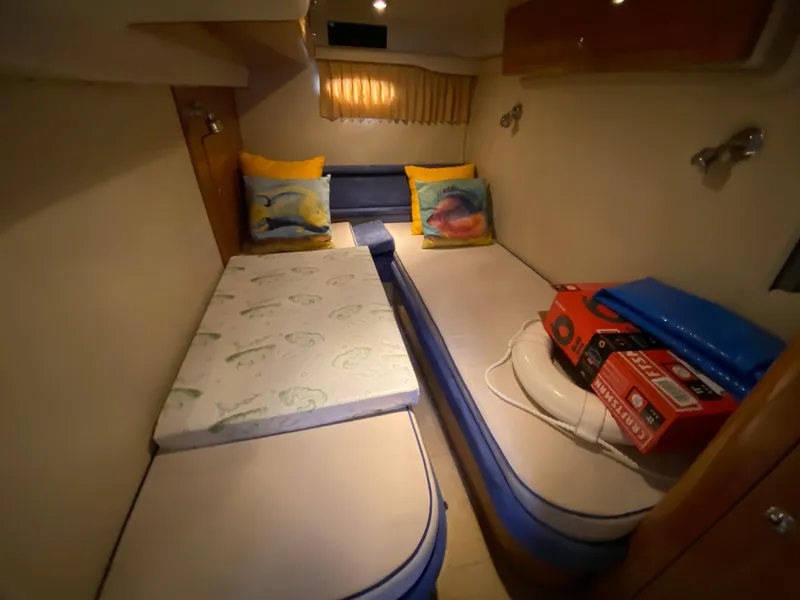 Slide: The Image of 2004 Regal 3860 Commodore cabin with twin beds and colorful pillows. - 17