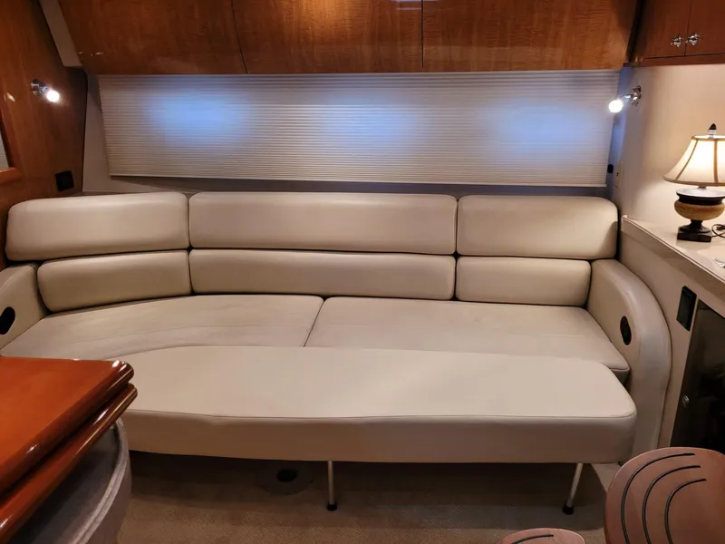 Slide: The Image of 2004 Regal 3860 Commodore yacht interior with beige leather sofa and wooden cabinetry. - 42