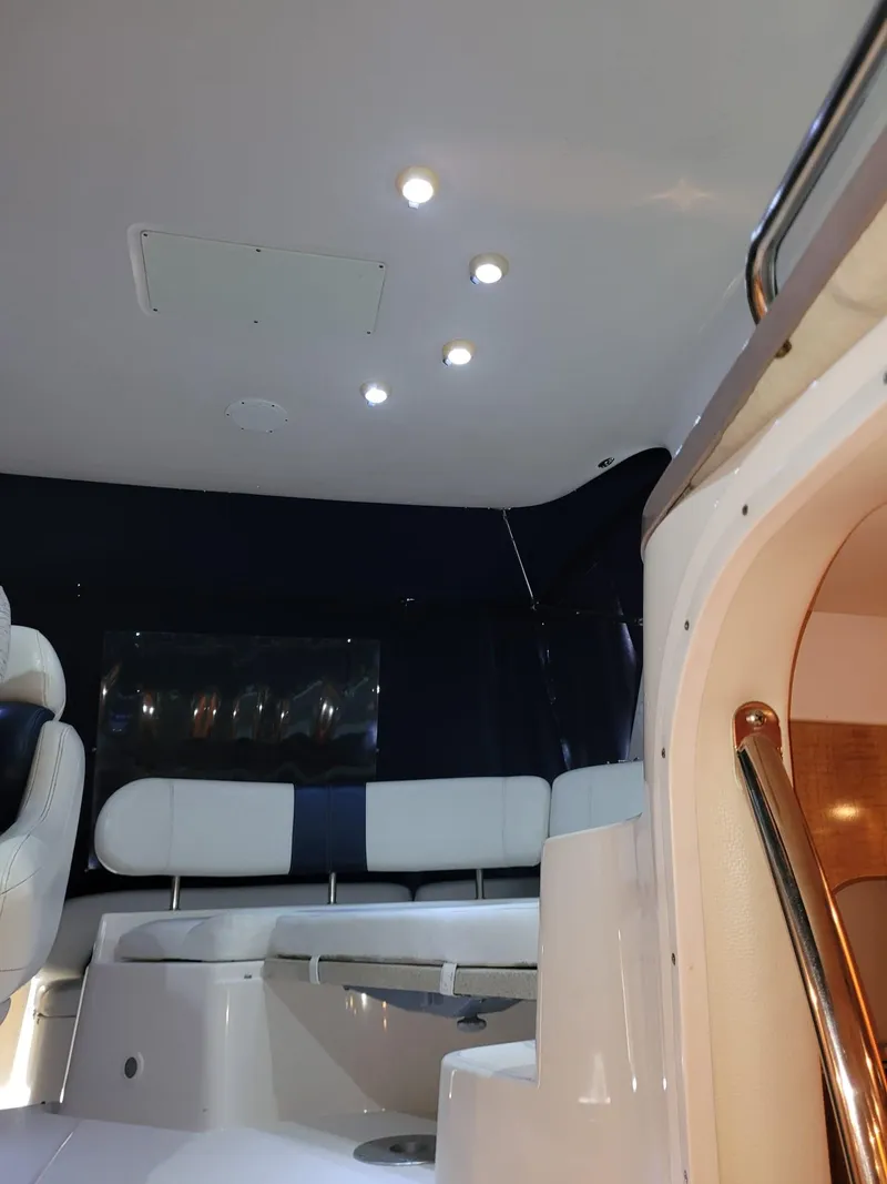 Slide: The Image of Interior of 2004 Regal 3860 Commodore yacht with white seating and ceiling lights. - 48