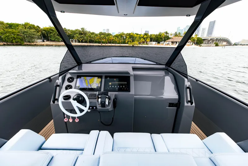 Slide: The Image of 2022 Vanquish Yachts VQ40 helm station with modern navigation system on a serene waterway. - 15