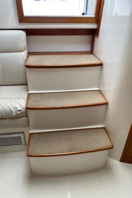 Slide: The Image of Interior of a 2000 Cabo 35 Express boat with white leather seating and a small table. - 33