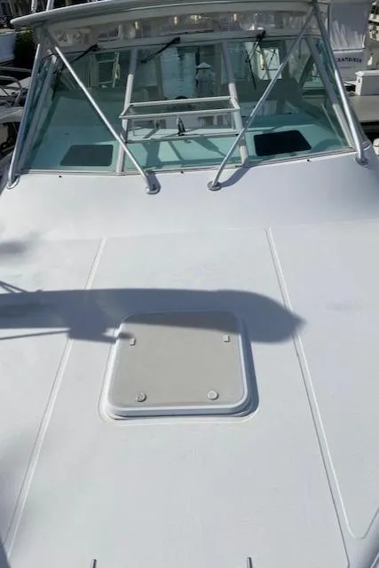 Slide: The Image of Bow of a 2000 Cabo 35 Express boat docked by calm waters. - 39