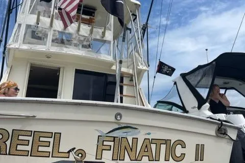 Slide: The Image of 1989 Viking 41 Sportfish Convertible with flags and people on board. - 38