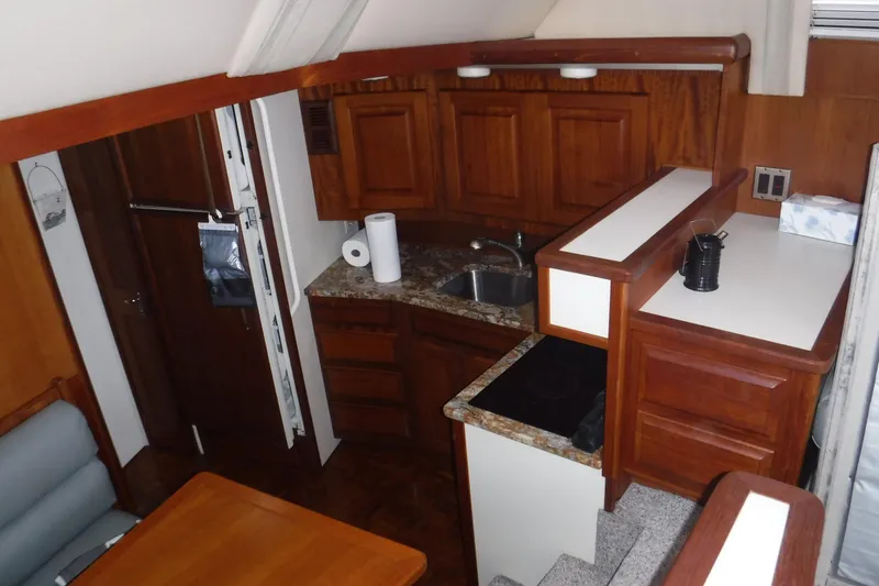 Slide: The Image of 1989 Viking 41 Sportfish Convertible interior with wooden cabinetry and compact kitchen area. - 65