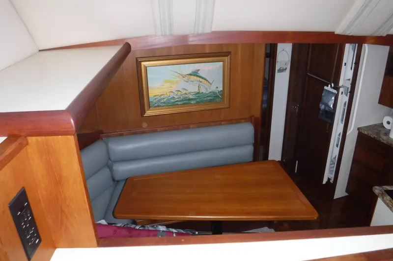 Slide: The Image of Interior of 1989 Viking 41 Sportfish Convertible with dining area and marine artwork. - 66