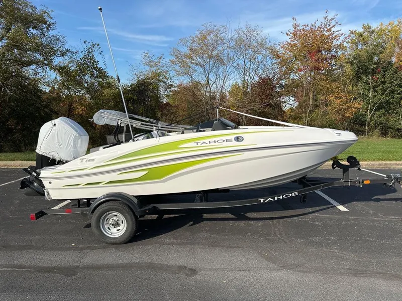 Slide: The Image of 2024 Tahoe T16 boat on trailer, parked outdoors with trees in the background. - 0