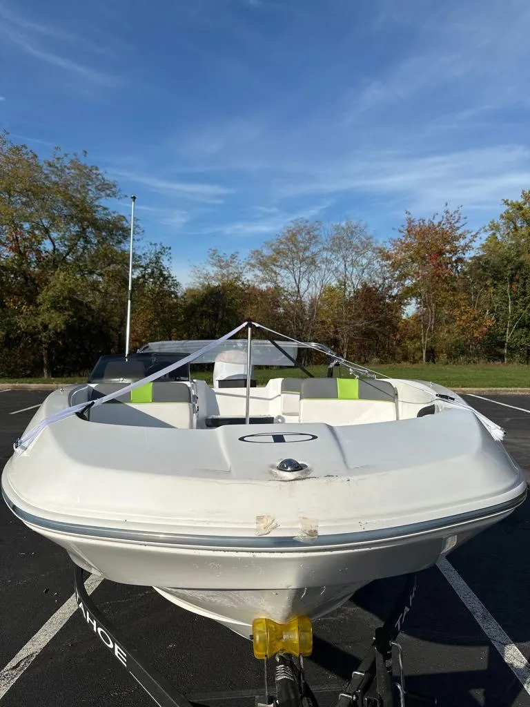 Slide: The Image of 2024 Tahoe T16 boat in parking lot, surrounded by trees under a clear sky. - 1