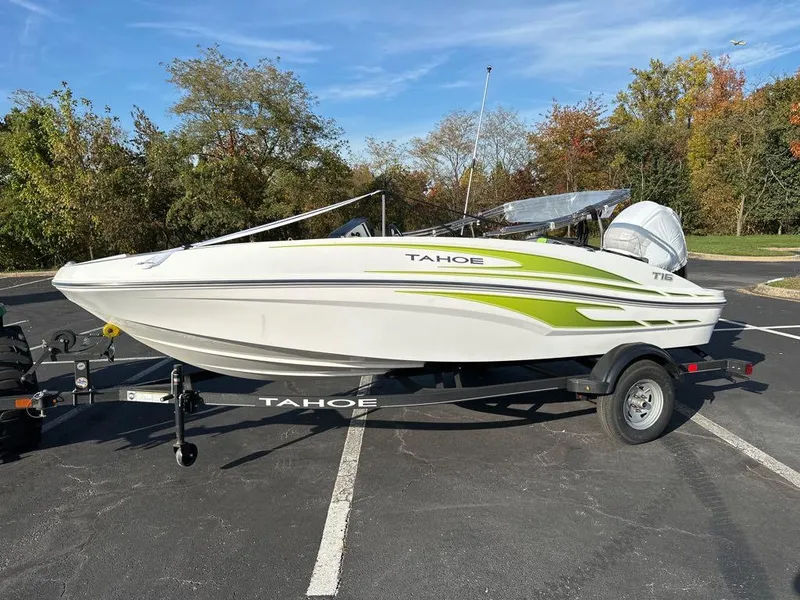 Slide: The Image of 2024 Tahoe T16 boat on trailer in parking lot, featuring sleek design and green accents. - 2