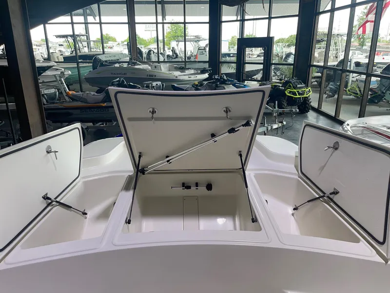 Slide: The Image of 2024 Mako Pro Skiff 19 CC boat with open storage compartments in showroom. - 10