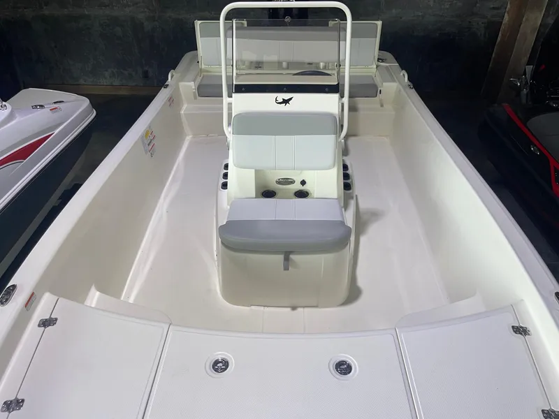 Slide: The Image of 2024 Mako Pro Skiff 19 CC center console boat interior, white with seating and storage. - 12
