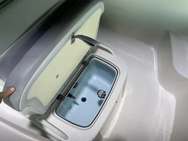 Slide: The Image of 2024 Mako Pro Skiff 19 CC livewell compartment with open lid. - 13
