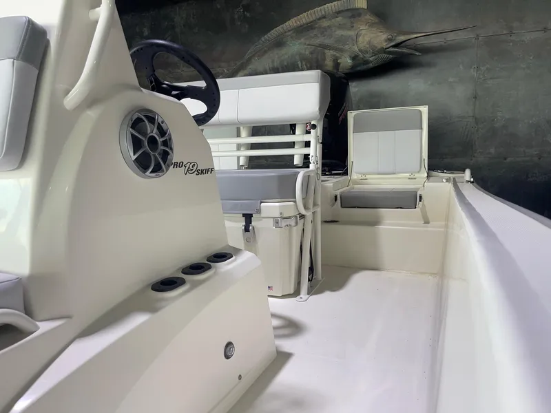 Slide: The Image of 2024 Mako Pro Skiff 19 CC interior with seating and storage compartments. - 15