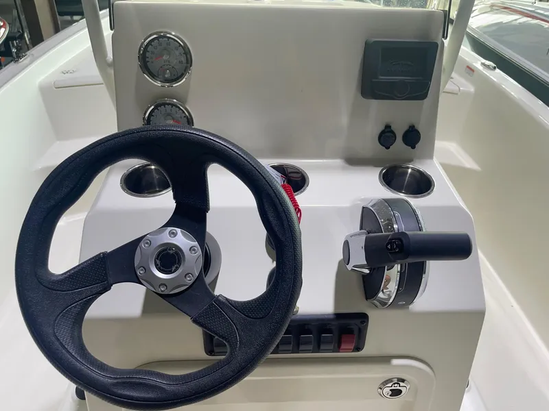 Slide: The Image of 2024 Mako Pro Skiff 19 CC center console with steering wheel and controls. - 21
