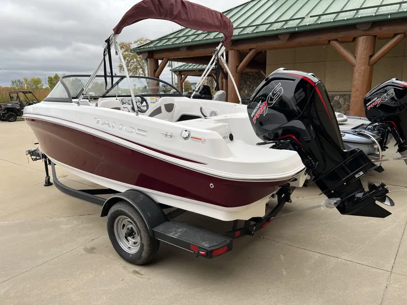 Slide: The Image of 2024 Tahoe 185 S boat with outboard motor on trailer, parked outdoors. - 3