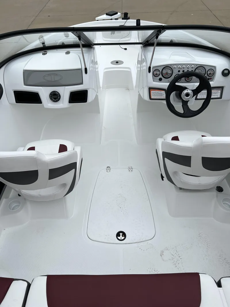 Slide: The Image of 2024 Tahoe 185 S boat interior with white and maroon seating, dashboard, and steering wheel. - 6