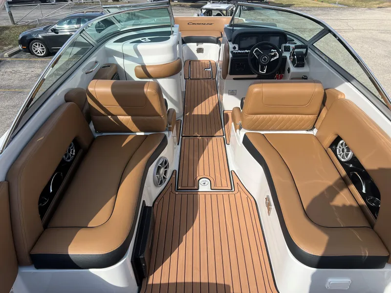 Slide: The Image of 2024 Crownline E305 boat interior with tan leather seating and modern dashboard. - 4