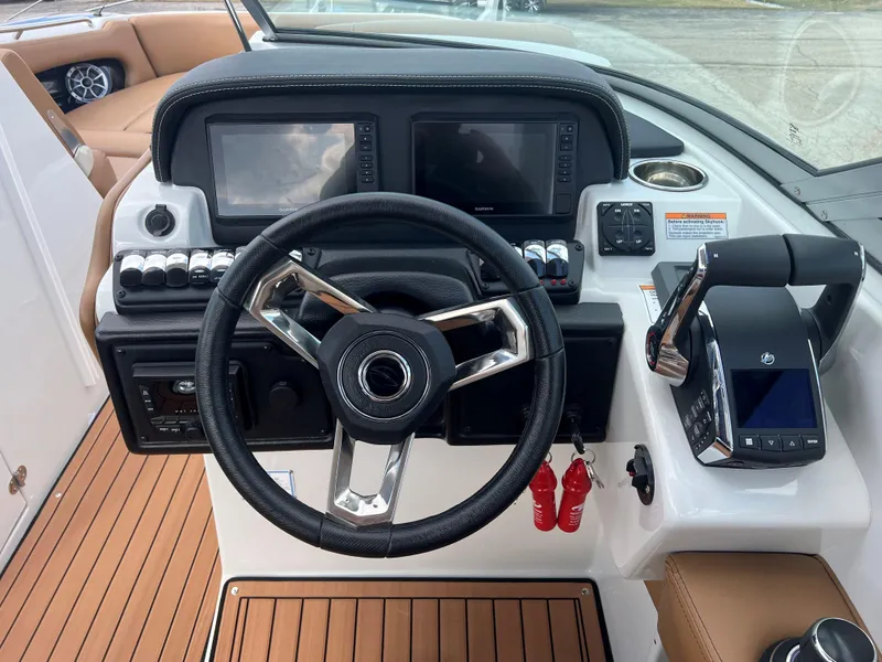 Slide: The Image of 2024 Crownline E305 boat dashboard with steering wheel and control panel. - 5