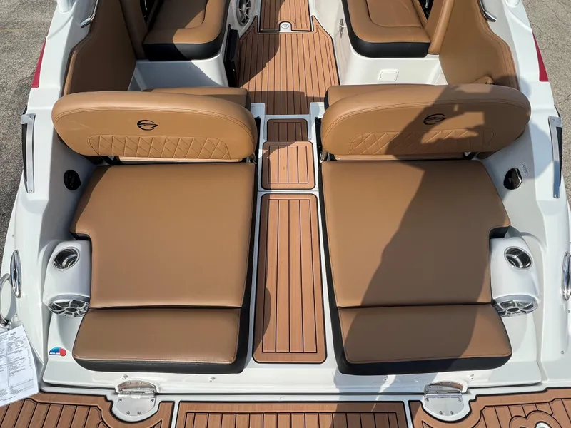 Slide: The Image of 2024 Crownline E305 boat interior with tan leather seats and teak flooring. - 6