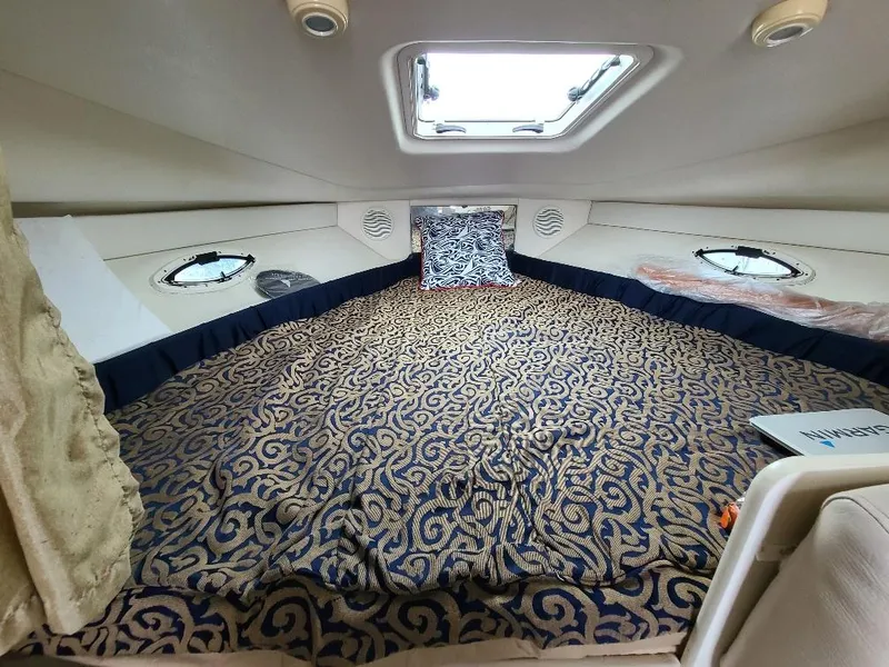 Slide: The Image of Interior cabin of 2003 Bayliner 285 Ciera with patterned bedding and overhead hatch. - 10