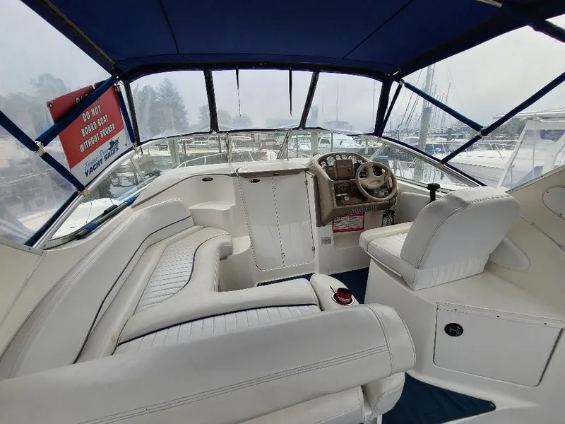 Slide: The Image of 2003 Bayliner 285 Ciera boat interior with white seating and steering console. - 19