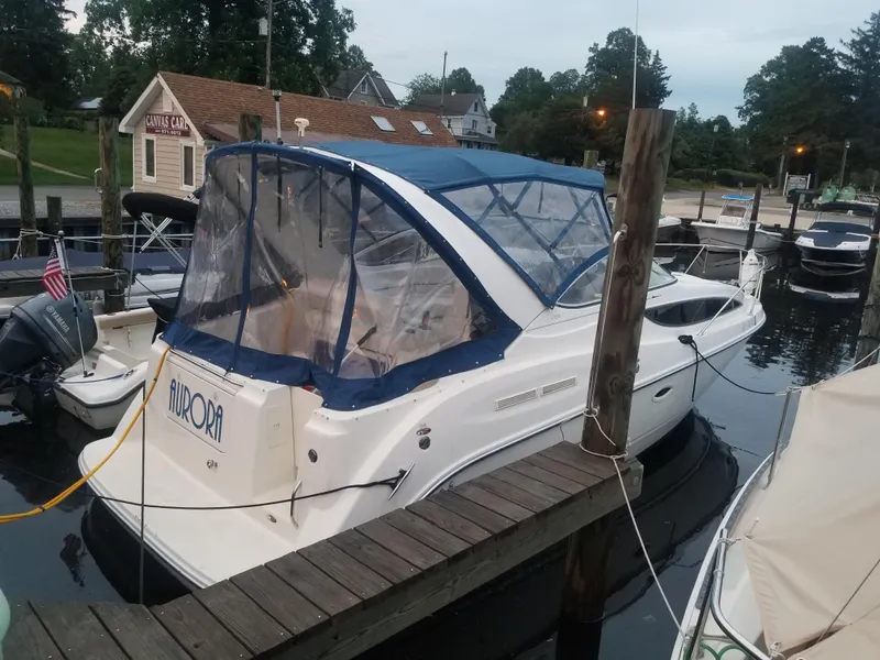 Slide: The Image of 2003 Bayliner 285 Ciera boat docked at marina with blue canopy. - 2