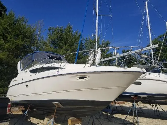 Slide: The Image of 2003 Bayliner 285 Ciera boat on stands, surrounded by trees and blue sky. - 23