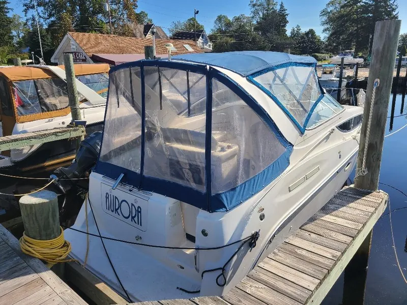 Slide: The Image of 2003 Bayliner 285 Ciera boat docked with blue canopy and clear windows. - 3