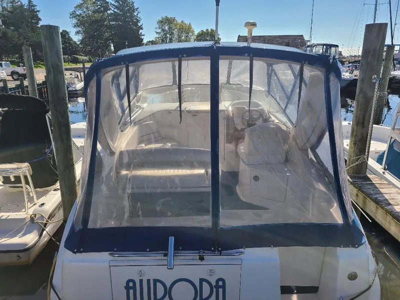Slide: The Image of 2003 Bayliner 285 Ciera boat docked with clear enclosure, sunny marina background. - 4