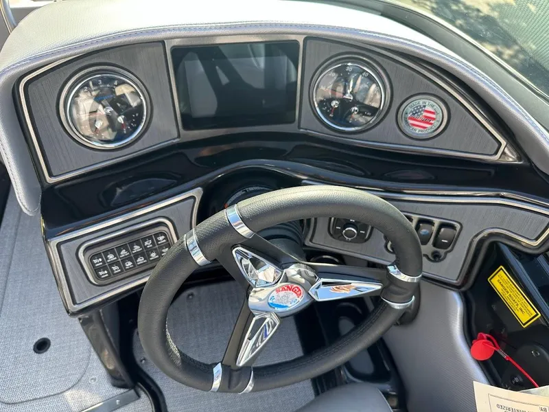 Slide: The Image of 2024 Sanger V215 SX boat dashboard with steering wheel, gauges, and control panel. - 13