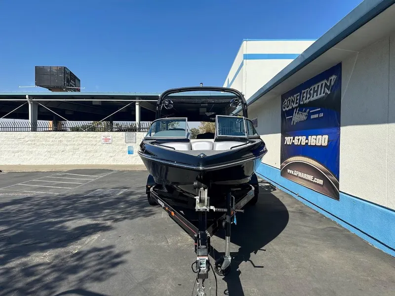 Slide: The Image of 2024 Sanger V215 SX boat on trailer in dealership lot. - 2
