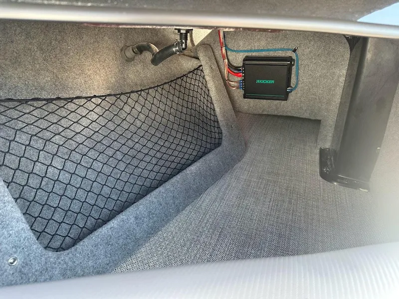 Slide: The Image of 2024 Sanger V215 SX boat interior storage compartment with netting and wiring. - 27