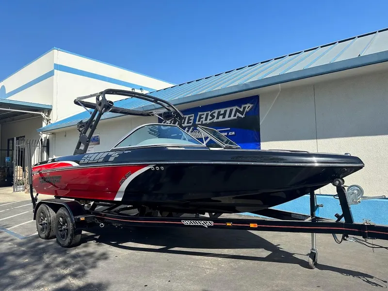 Slide: The Image of 2024 Sanger V215 SX boat on trailer, black and red, parked outside. - 3