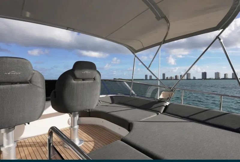 Slide: The Image of 2021 Azimut S6 Sports Fly yacht deck with seating, ocean view, and city skyline. - 9