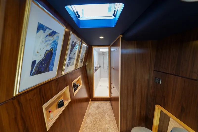 Slide: The Image of Luxurious hallway in 2025 Archipelago 47 yacht with skylight and framed artwork. - 15