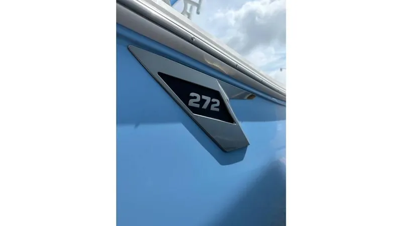 Slide: The Image of 2024 Blackfin 272 CC boat emblem on light blue hull. - 4