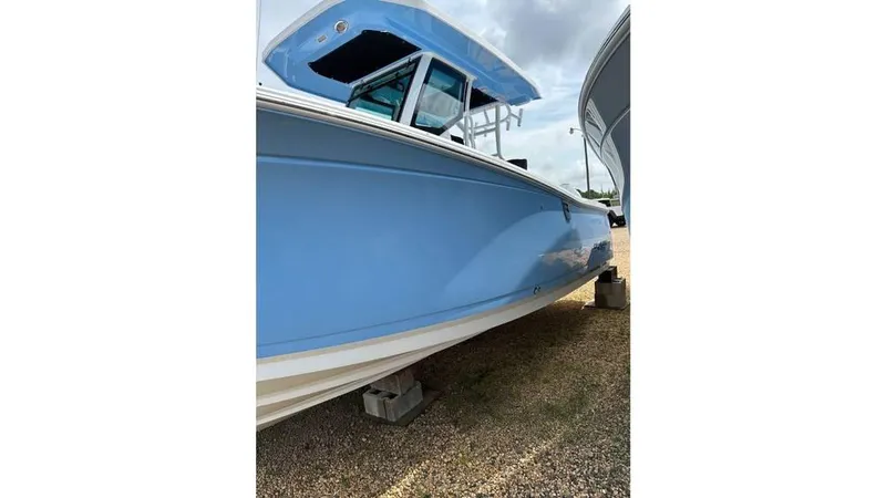 Slide: The Image of 2024 Blackfin 272 CC boat in light blue, side view on dry dock. - 5
