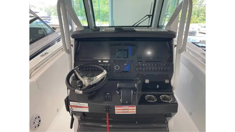 Slide: The Image of 2024 Blackfin 272 CC boat dashboard with steering wheel and control panel. - 8