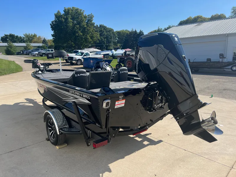 Slide: The Image of 2024 Lund 1875 Pro-V Bass XS boat, black, parked on a driveway. - 4