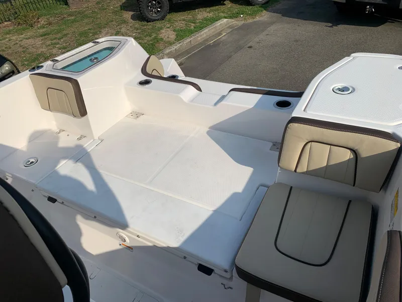 Slide: The Image of 2023 Yamaha Boats 255 FSH Sport E deck area with seating and storage compartments. - 10