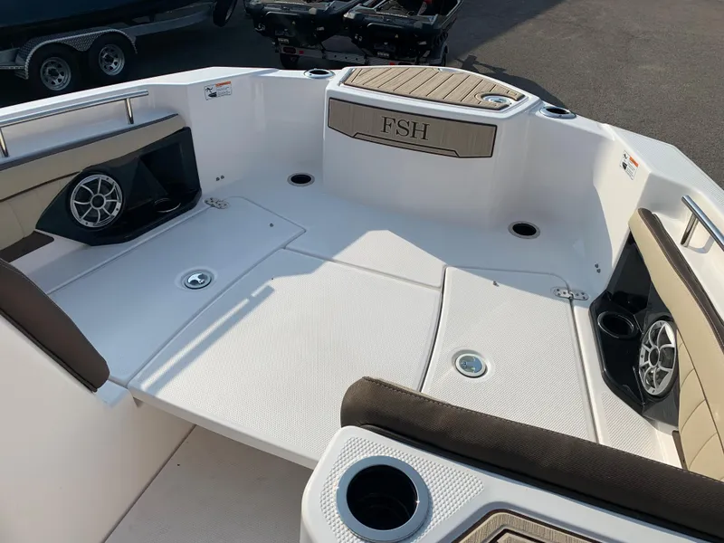 Slide: The Image of 2023 Yamaha Boats 255 FSH Sport E interior, featuring spacious seating and built-in speakers. - 14