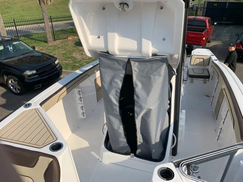 Slide: The Image of 2023 Yamaha Boats 255 FSH Sport E center console with storage compartment open. - 19