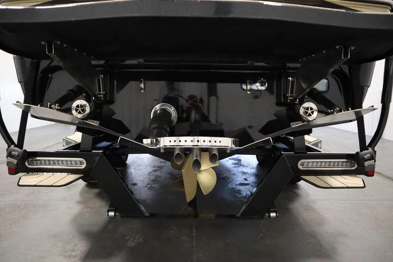 Slide: The Image of 2024 Centurion Ri230 boat stern with propeller and trim tabs in a showroom. - 32