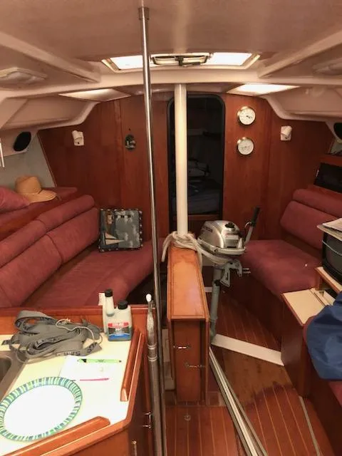 Slide: The Image of Interior of 1987 Hunter Legend 37 sailboat with red seating and wooden finishes. - 10